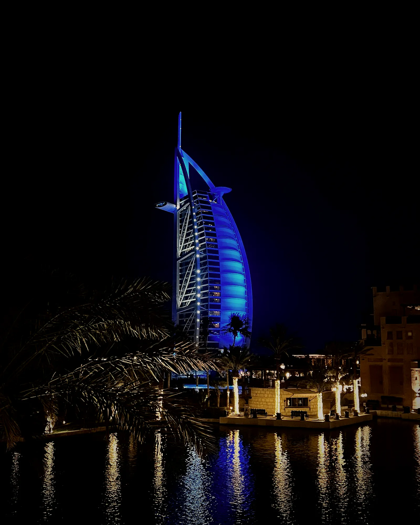 Burj Al Arab lit at night with its reflection, Dubai